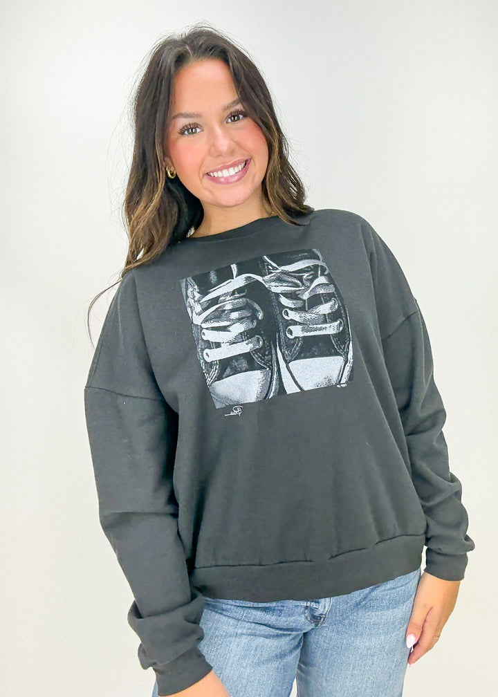 Person wearing a dark gray sweatshirt with a graphic design