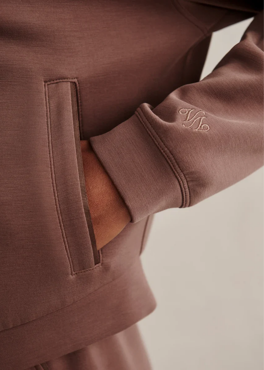 Close up of a woman wearing a coffee colored sweat set.