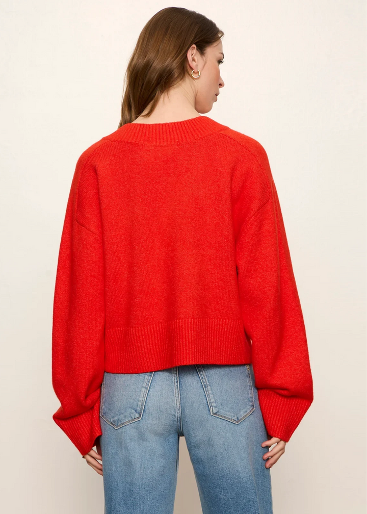 Woman wearing a red v-neck sweater.