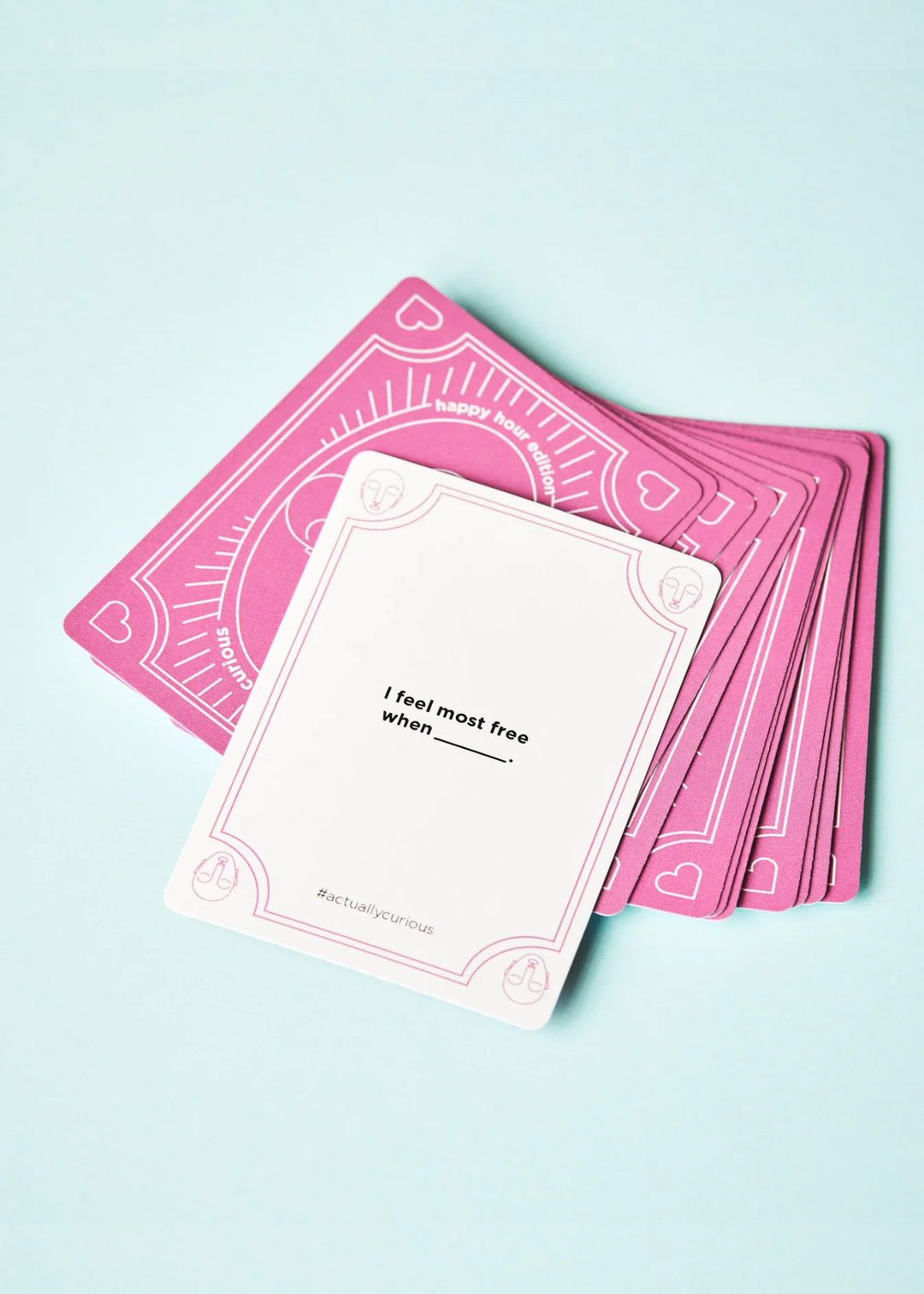 A white card with a question laying on top of pink cards