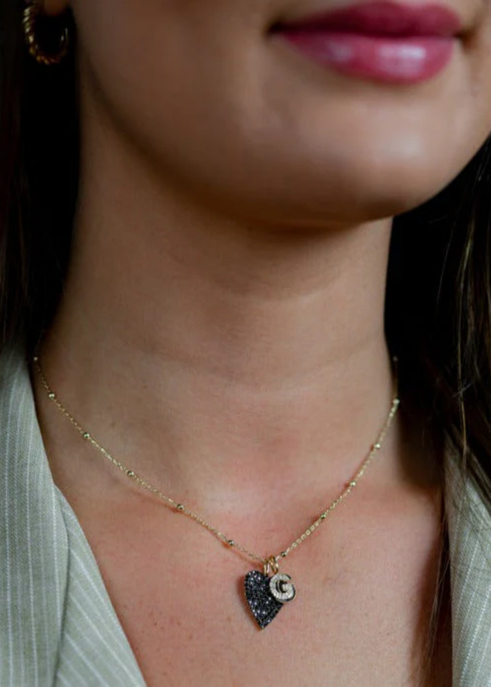 Woman wearing a Baby Ball Chain gold necklace with charms