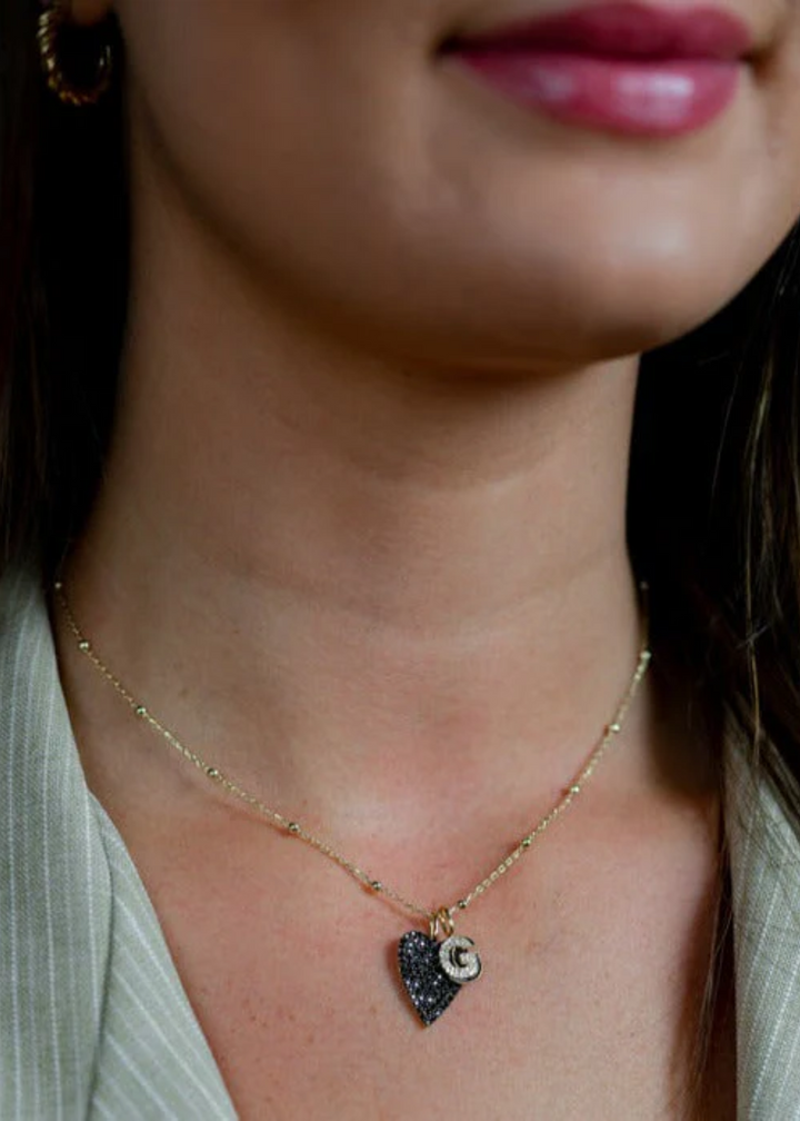 Woman wearing a Baby Ball Chain gold necklace with charms