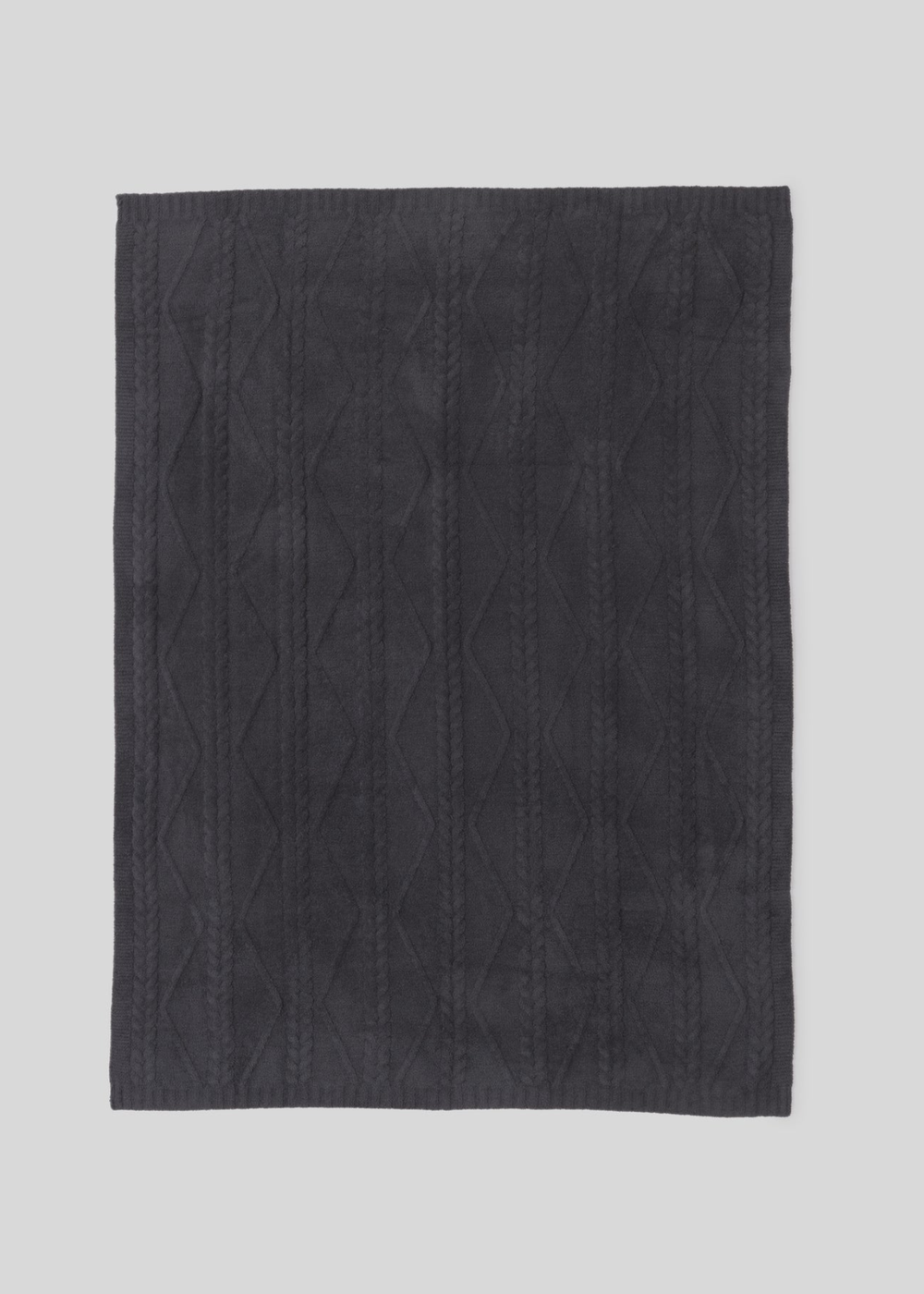 Dark grey blanket with a woven pattern laying on a white background