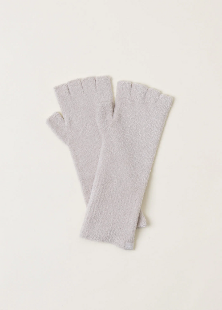 A pair of light grey fingerless gloves laying on a white background