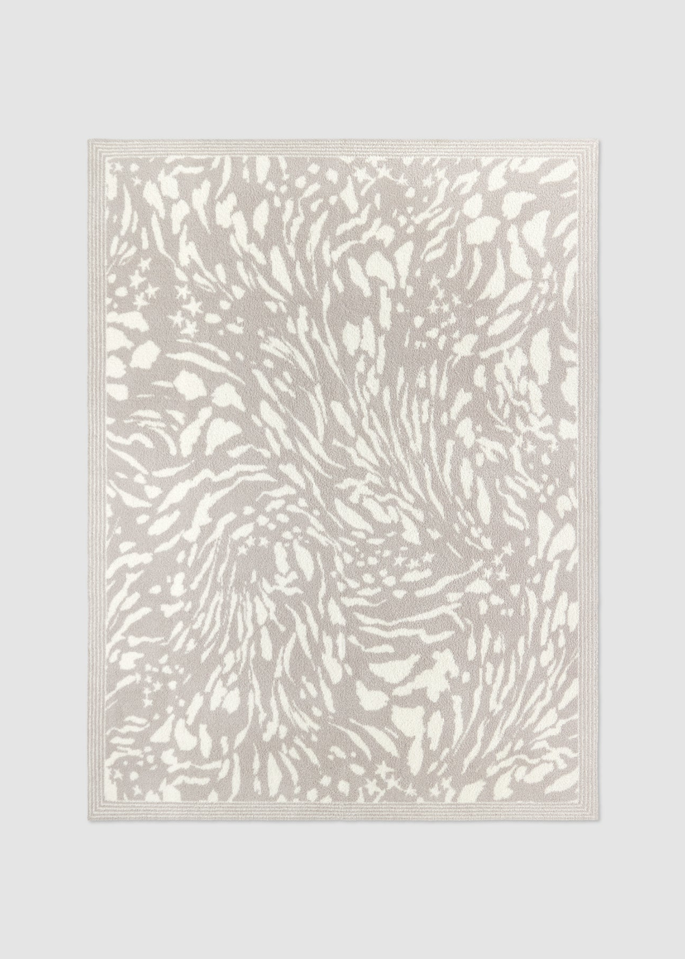 Grey and cream animal print blanket laying on a grey background
