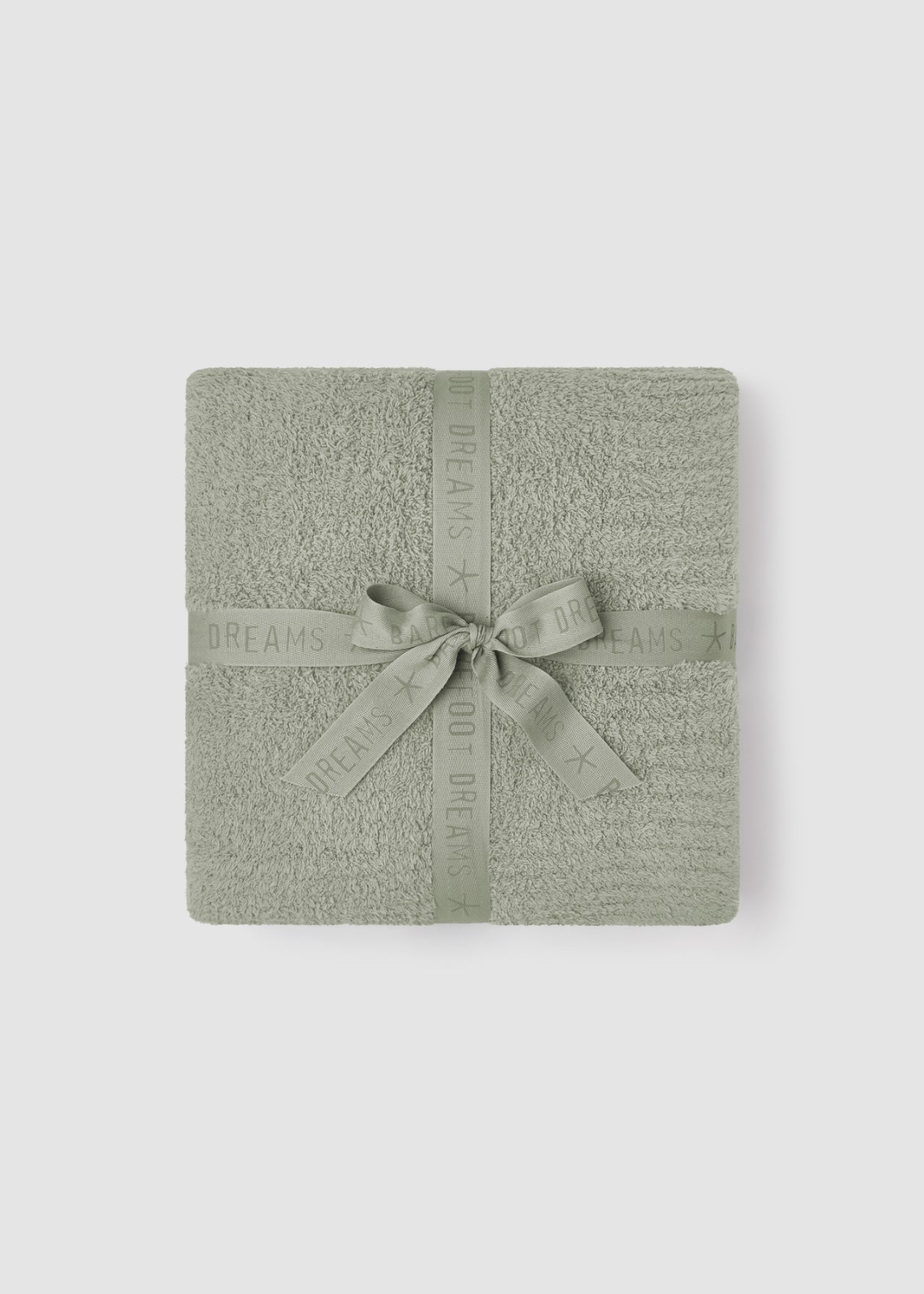 Green blanket folded and tied with a green bow sitting on a grey background