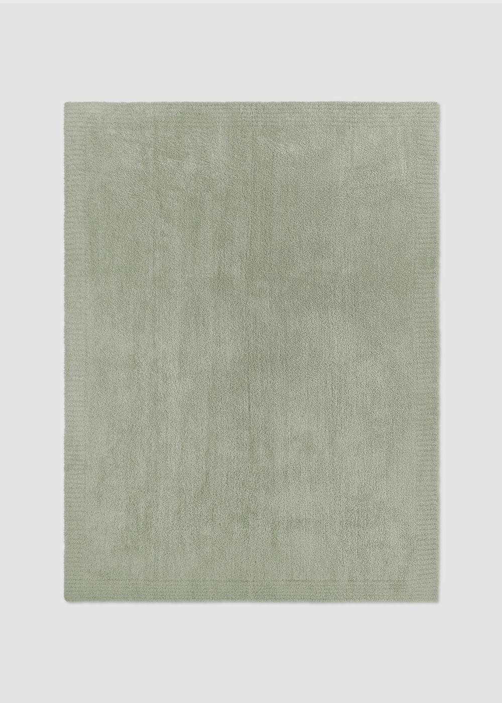 Green blanket laying on a gray background