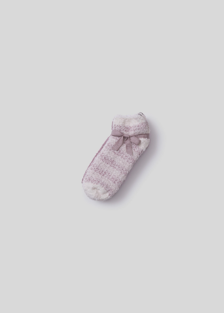 Pink and white stripe socks laying on top of pink socks tied together with a pink ribbon on a white background
