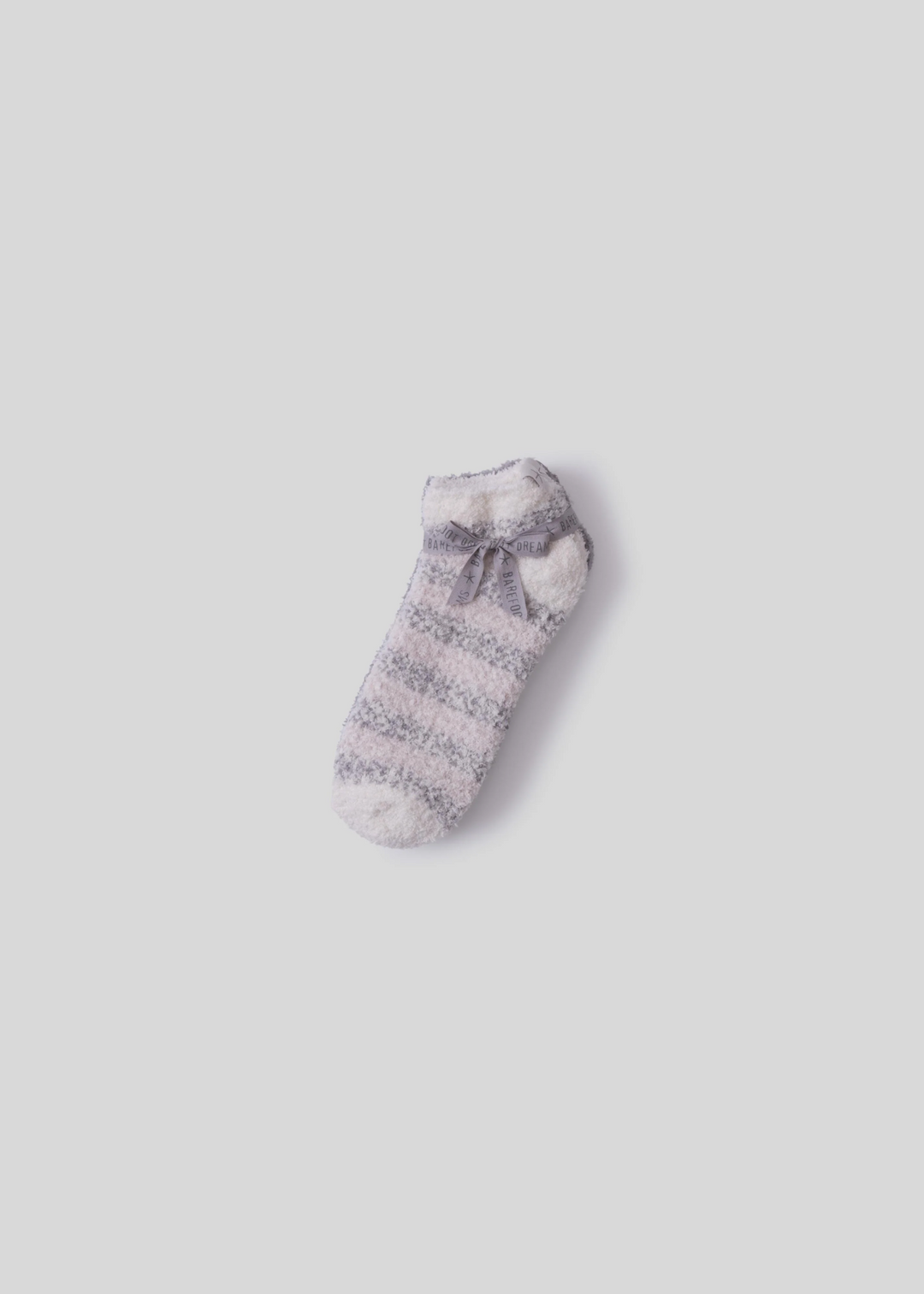 Grey and white striped ankle sock laying on top of grey socks tied together with a grey bow and laying on a white background