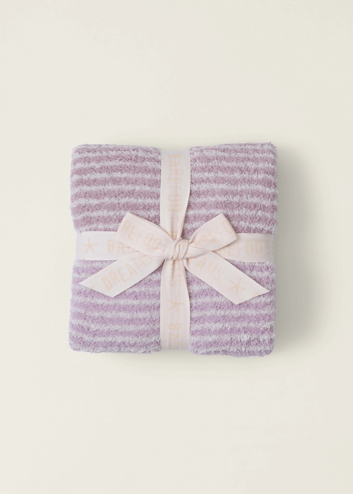A pink striped blanket folded with a ribbon on a white background