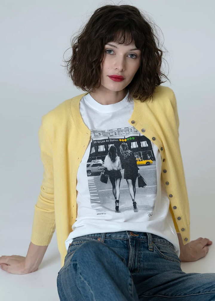 Woman wearing a graphic tee with jeans and a yellow cardigan