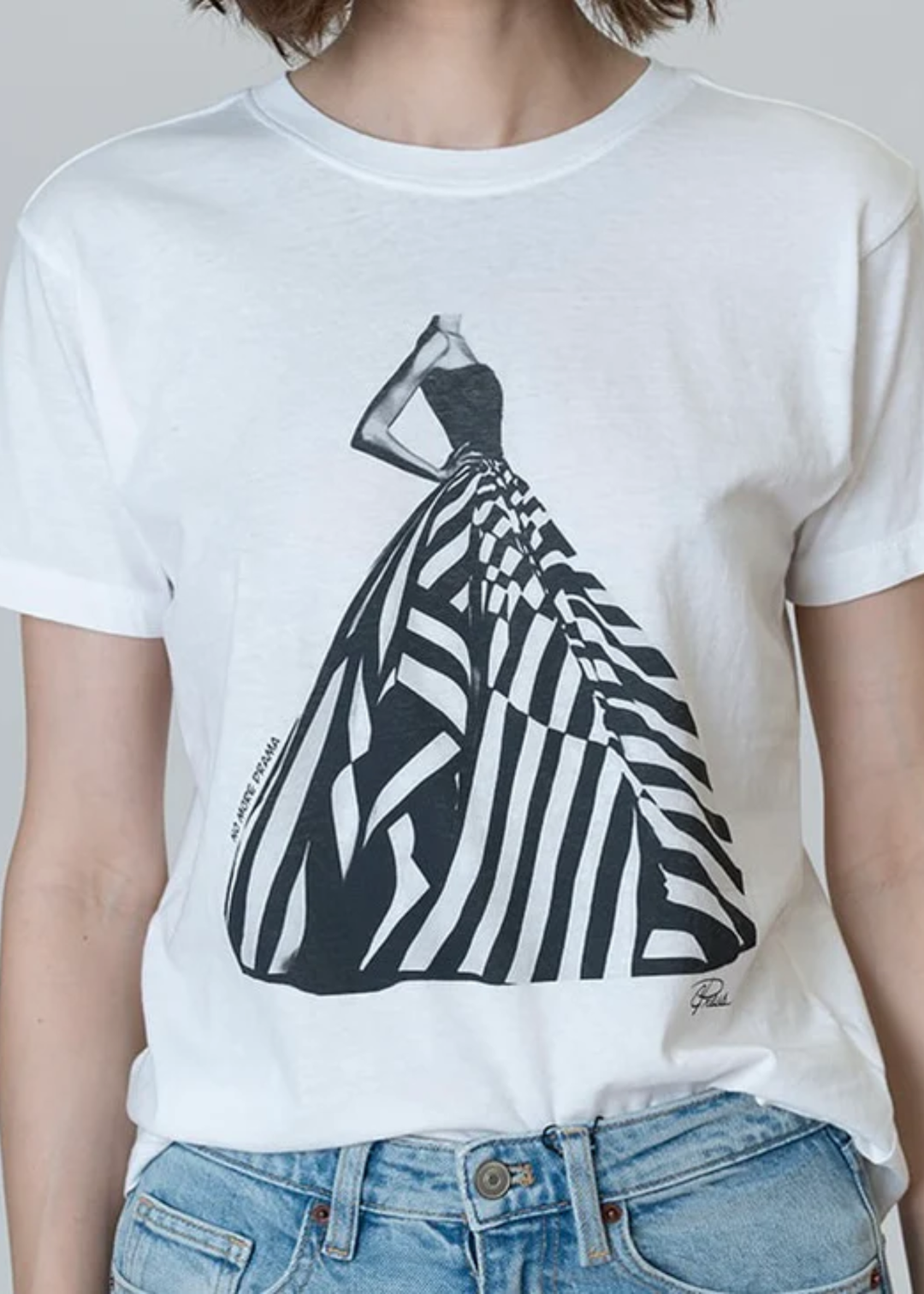 Woman wearing a white graphic tee with a black & white dress graphic with jeans
