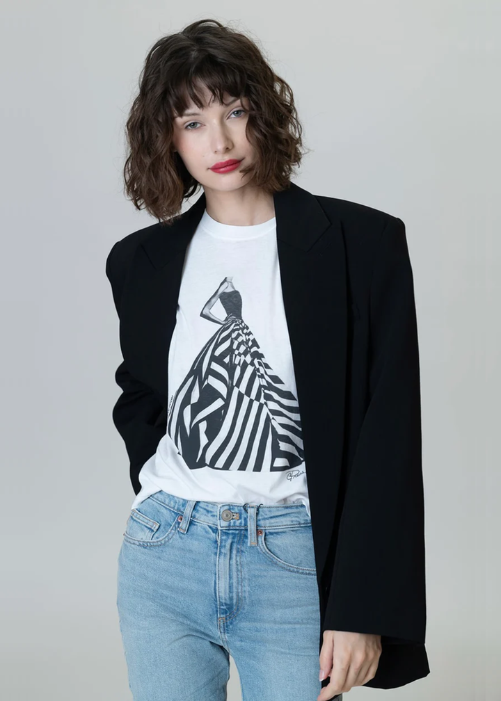 Woman wearing a white graphic tee with a black & white dress graphic with jeans and a black blazer