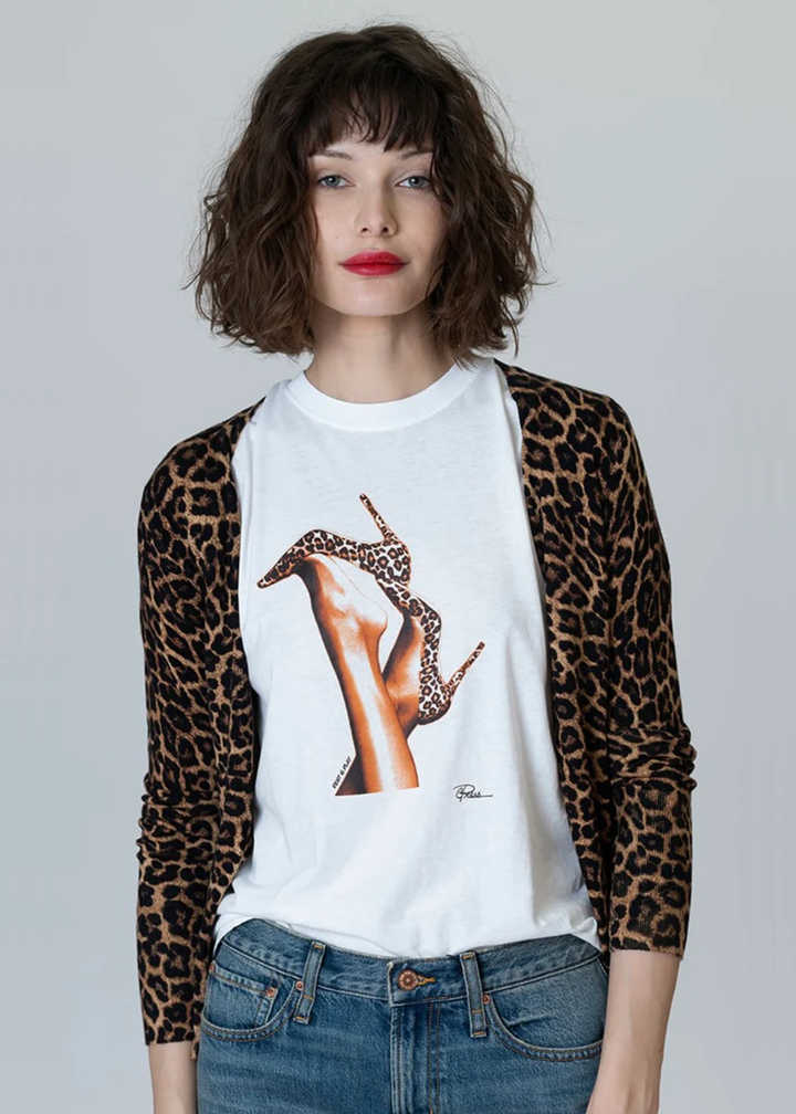 Woman wearing a white tee with a graphic of leopard print heels with jeans and a leopard print cardigan