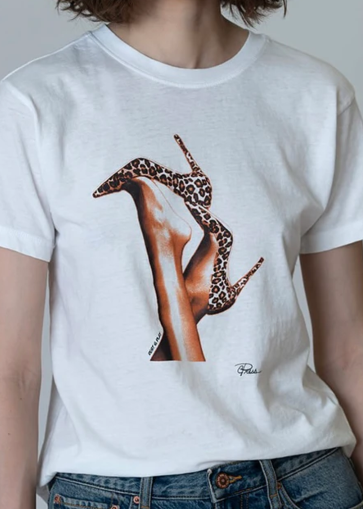 Woman wearing a white tee with a graphic of leopard print heels with jeans