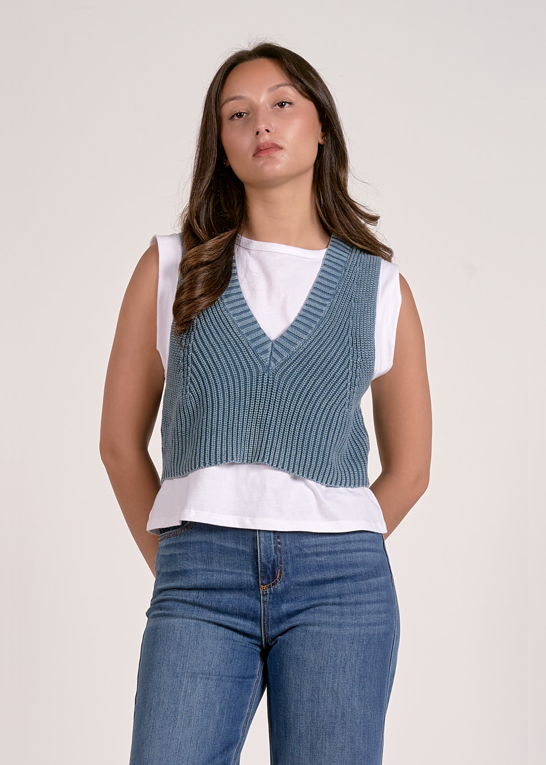 Woman wearing a blue and white layered top with jeans