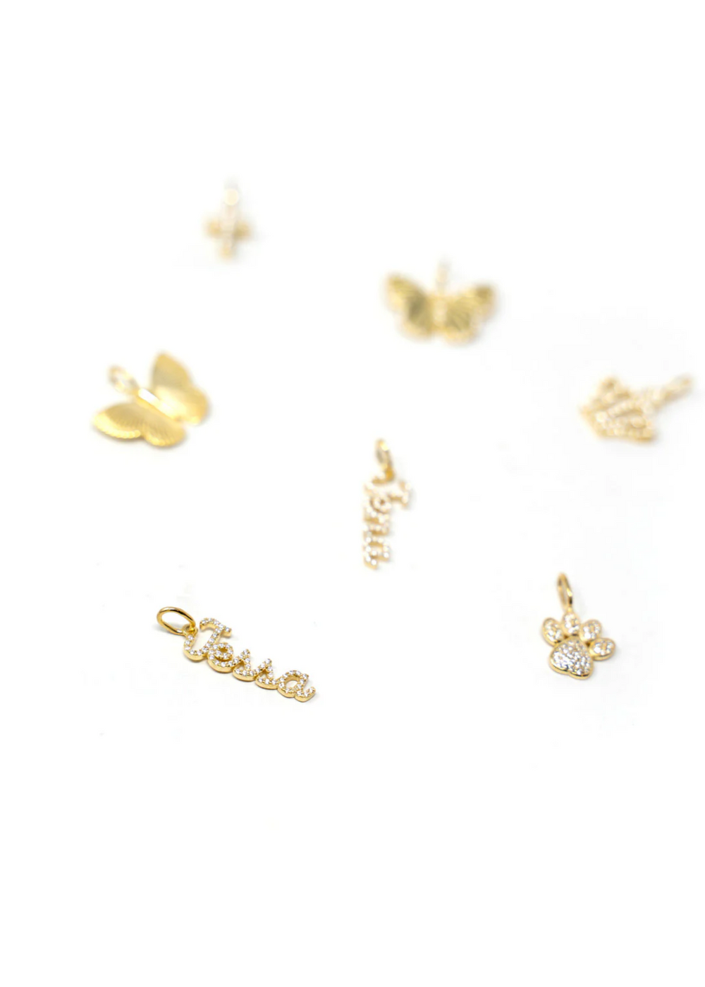 Various gold charms laying on a white background