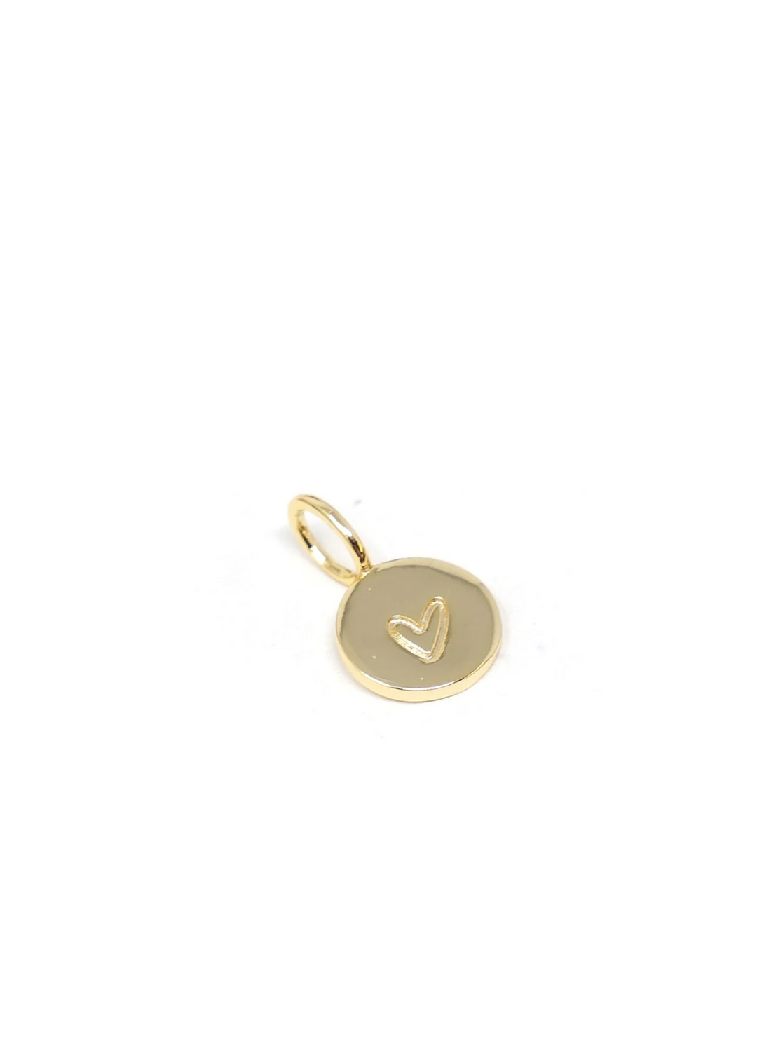 A gold circle charm with an engraved heart on a white background