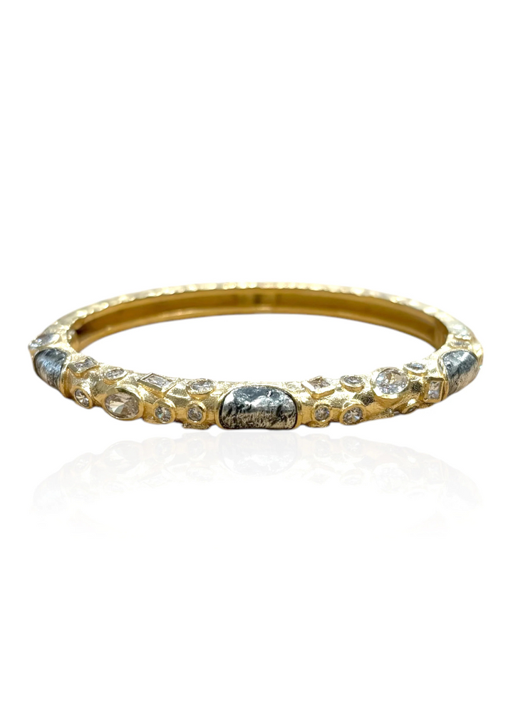 Gold bangle bracelet with silver coin and cz details on a white background