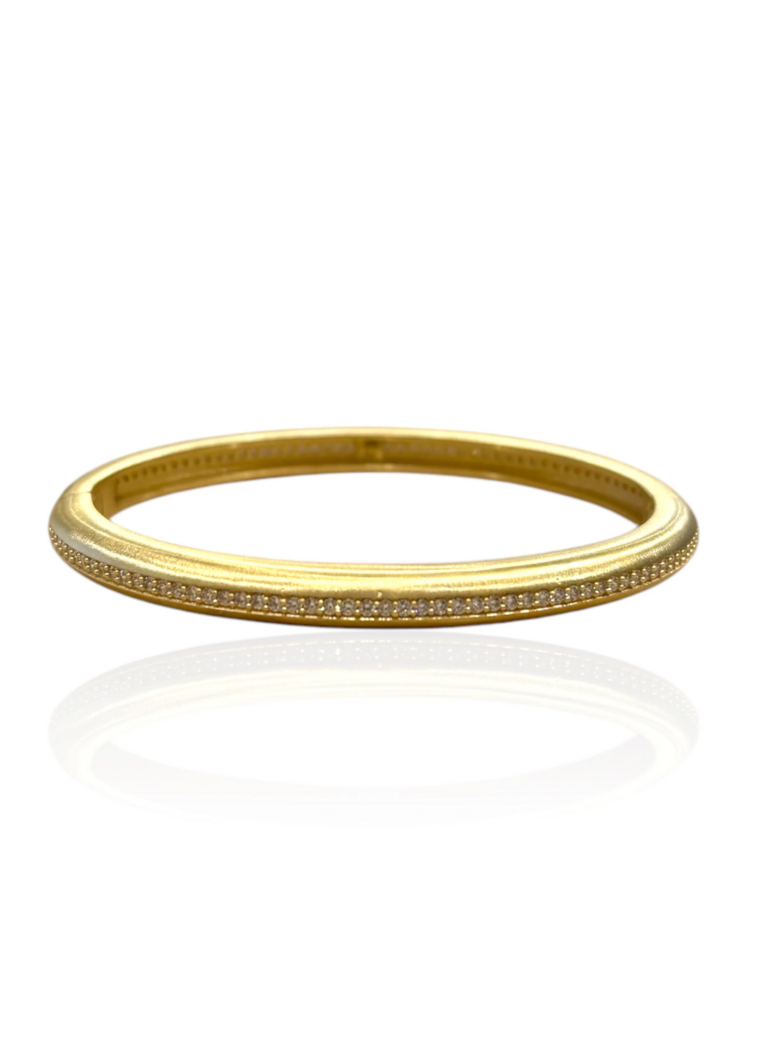 Gold bangle bracelet with pave CZs on a white background