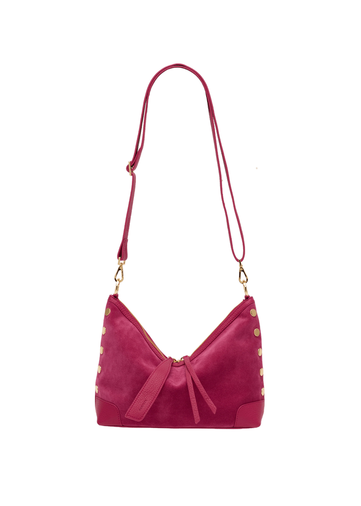 Fuschia suede and leather handbag with gold accents against a white background
