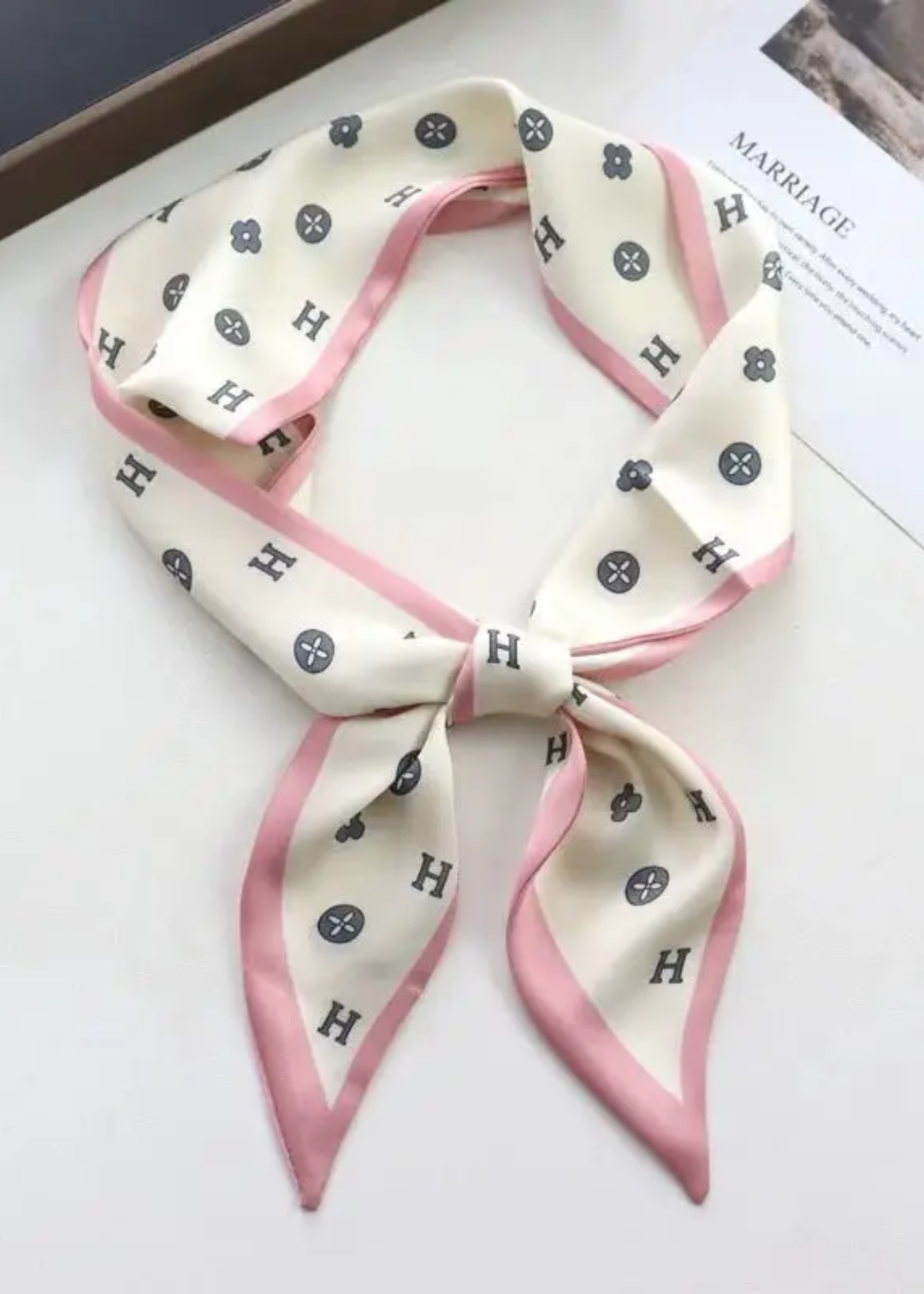 Cream scarf with a black pattern and pink trim