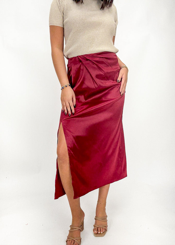 Person wearing a red satin skirt with a white background