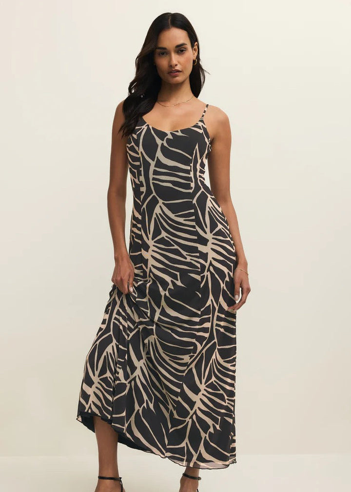 Woman wearing a black and beige patterned dress on a white background