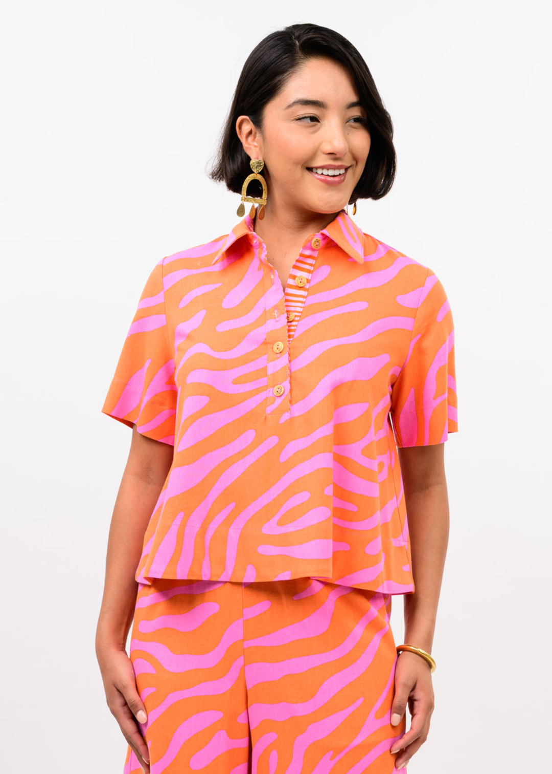 Woman wearing a pink and orange zebra print top with matching pants