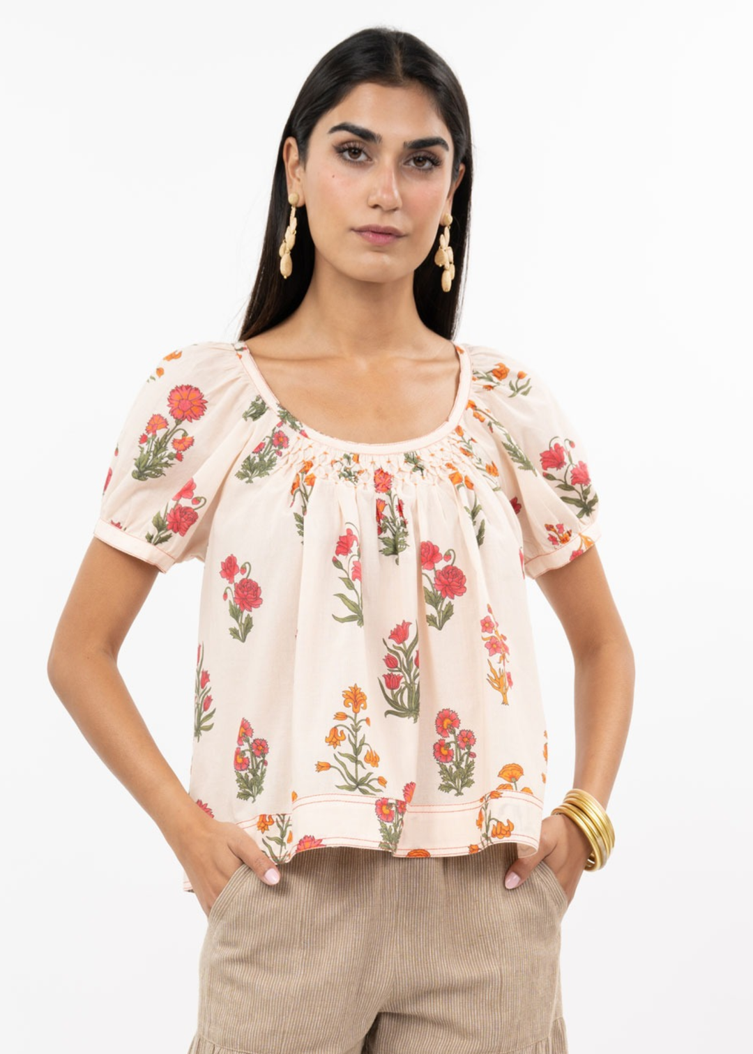 Woman wearing a floral top with brown pants