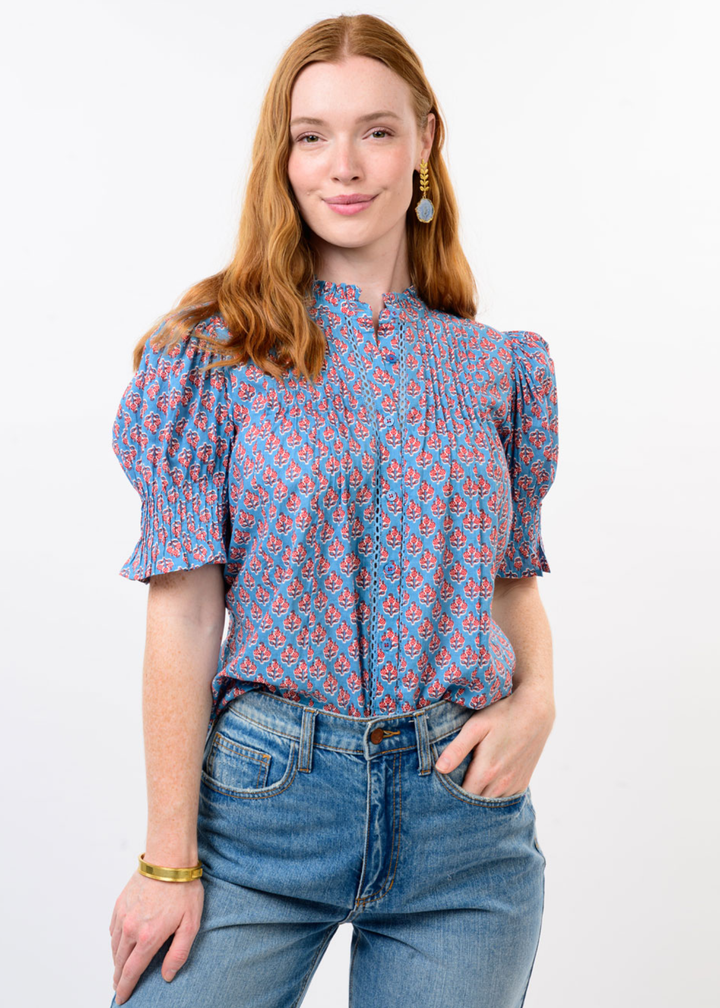 Woman wearing a blue and red floral top with jeans