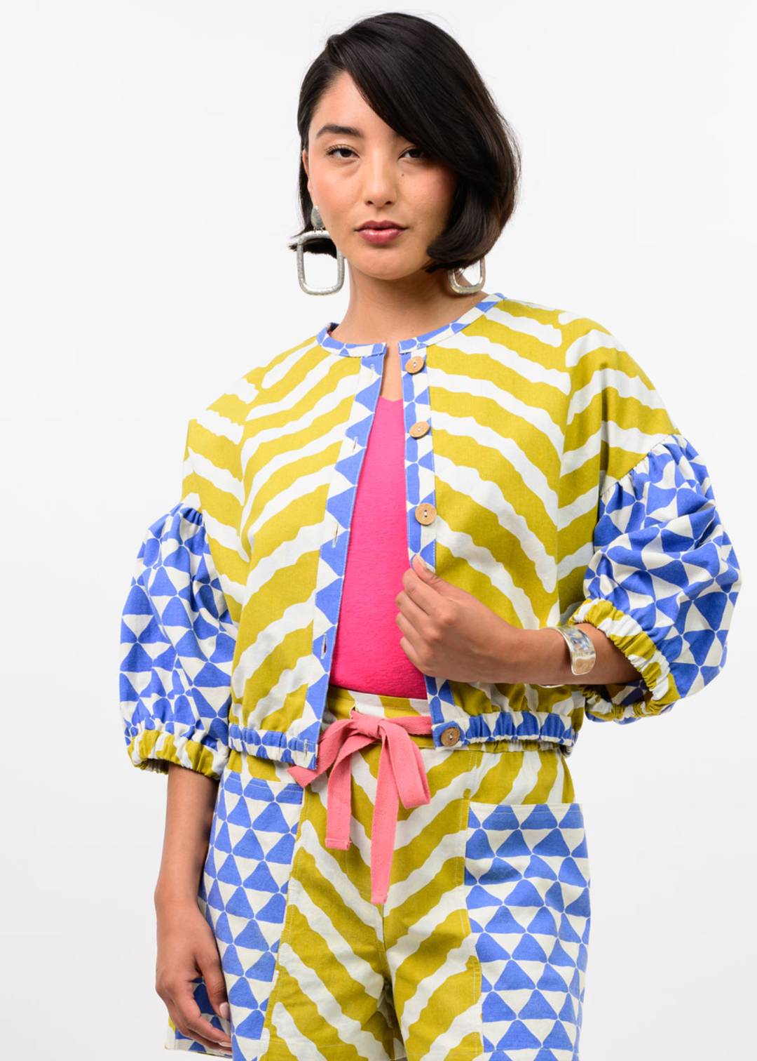 Woman wearing a yellow, blue, and white patterned cardigan with matching pants