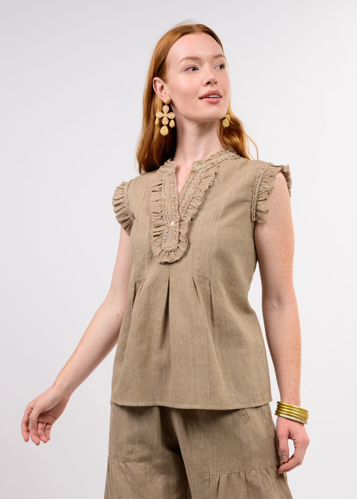 Woman wearing a brown top with ruffle details and matching pants
