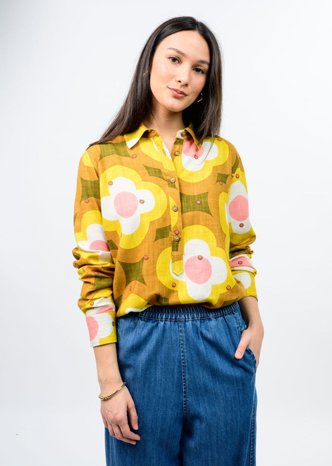 Woman in a multi colored, half button down floral top. 
