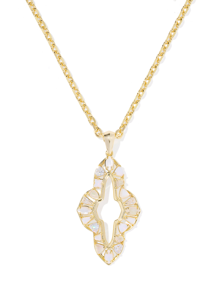 Gold necklace with a neutral stone colored pendant on a white background