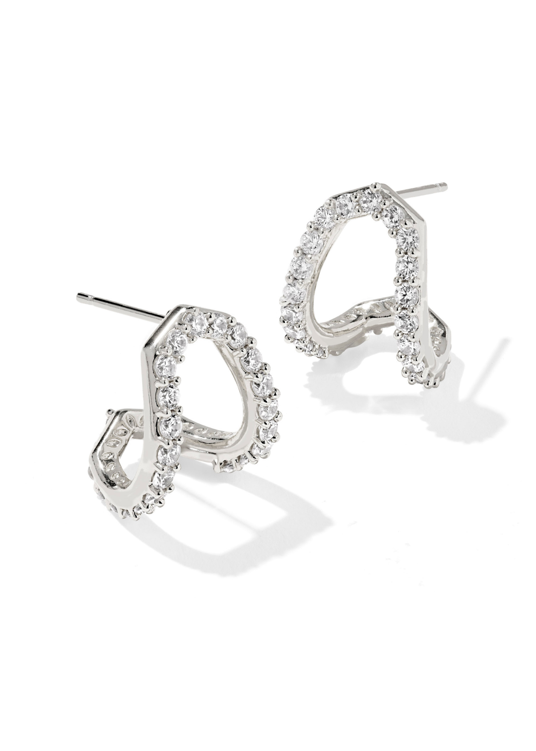 Rhodium huggie earrings framed with CZs on a white background