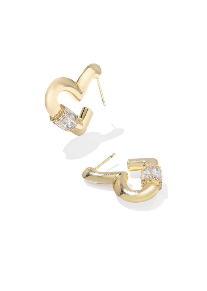 Gold heart shaped hoop earring with CZ details laying on a white background