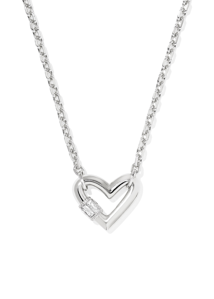 Rhodium necklace with a heart shaped pendant laying on a white background