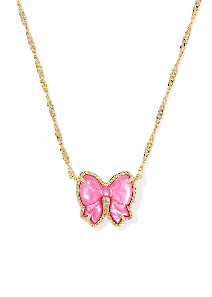 Gold necklace with a pink bow pendant on a white background