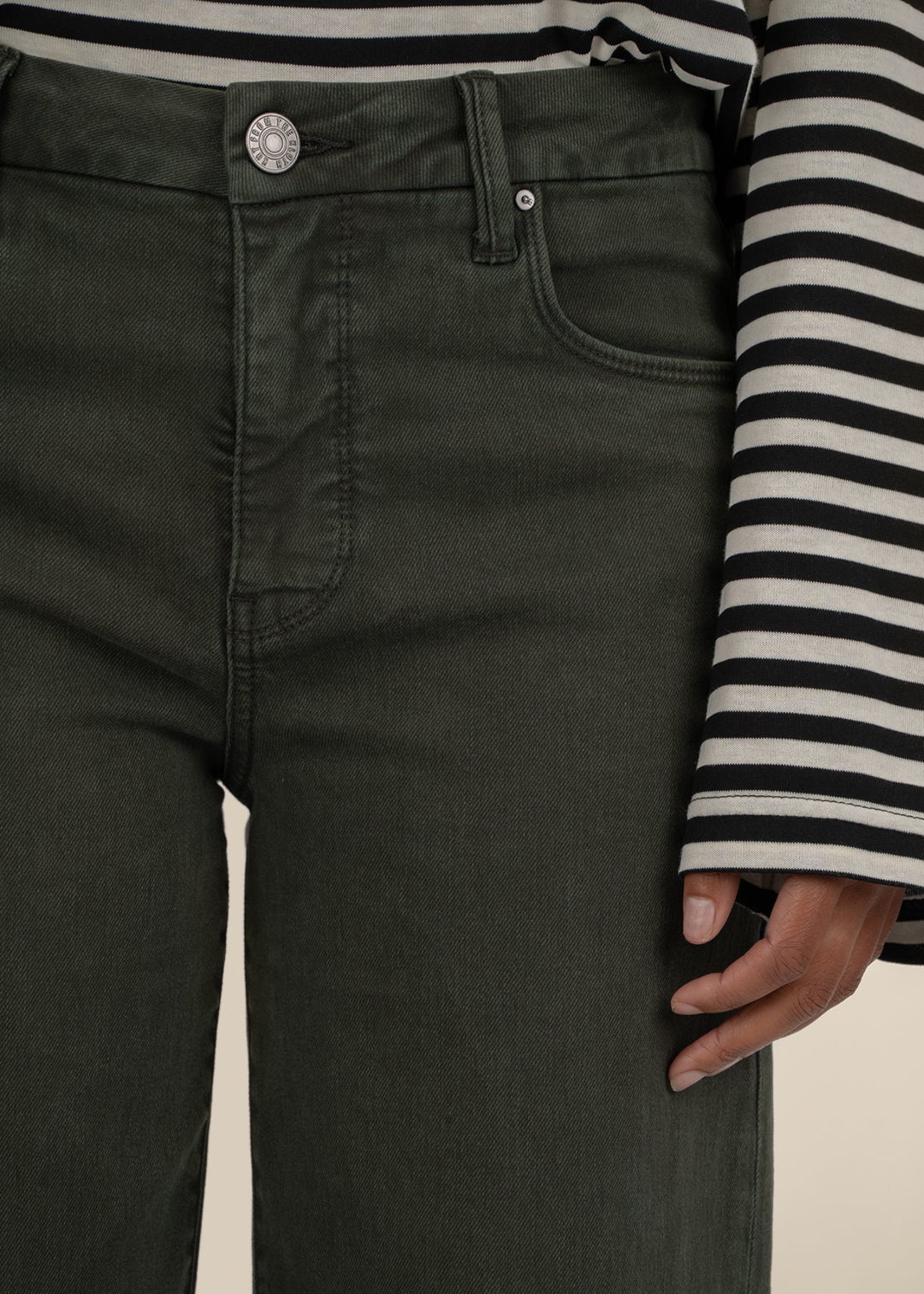 Close up of a woman wearing dark green jeans
