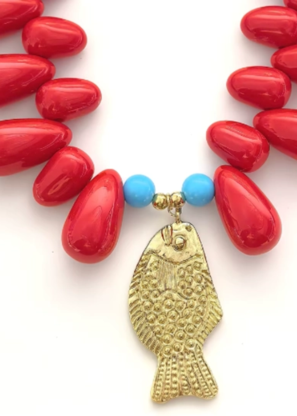 Red beaded necklace with a gold fish charm on a white background