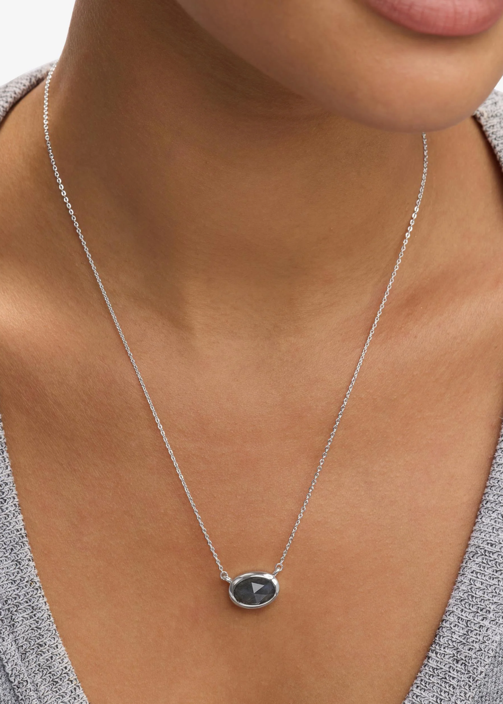 Woman wearing a silver framed labradorite pendant necklace