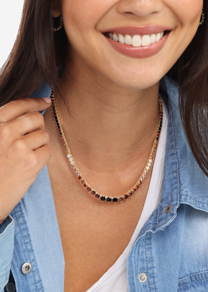 Woman wearing a tennis necklace with black, brown, and white simulated diamonds