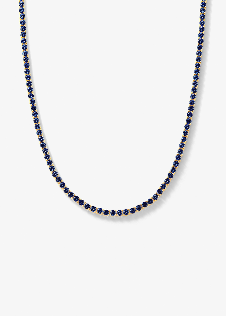 Gold framed blue sapphire tennis necklace on a white background