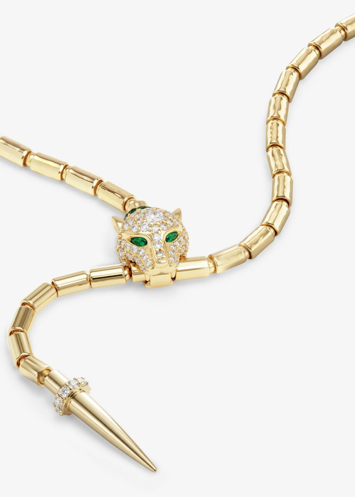 Close up of a gold lariat necklace with a jaguar head clasp