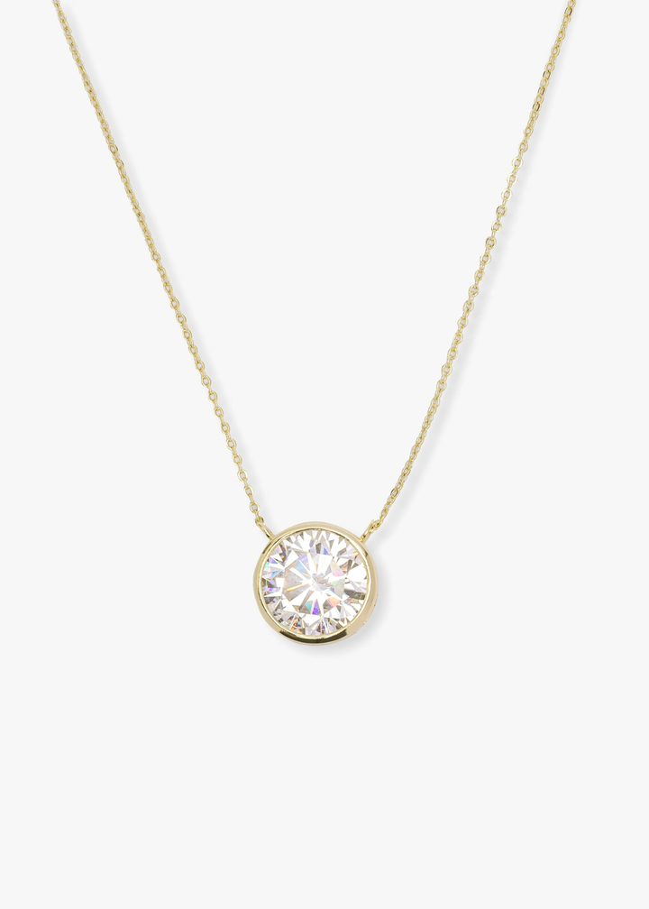 Gold necklace with a round simulated diamond pendant on a white background