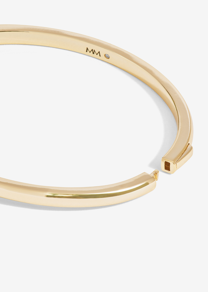 Close up of the clasp of a gold cuff bracelet