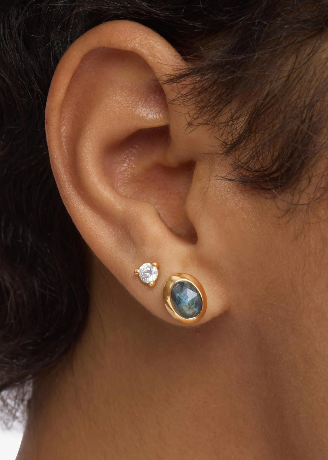 Woman wearing gold framed labradorite stud earrings