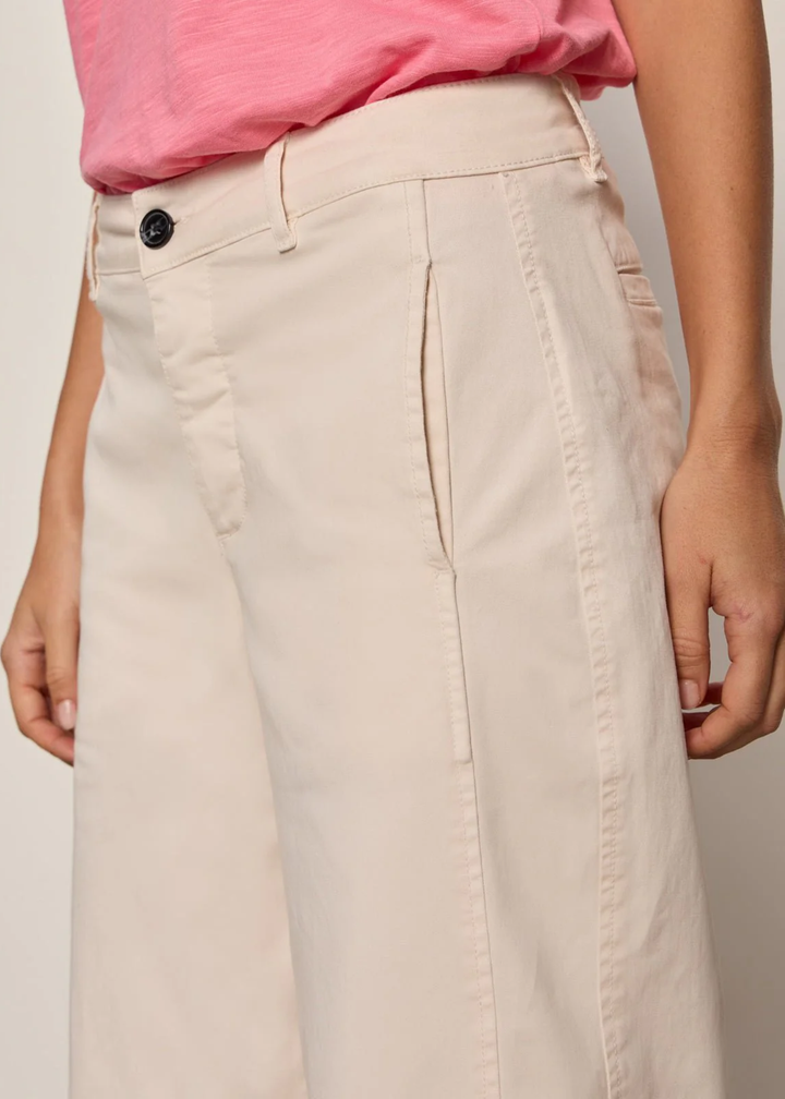 Close up of a woman wearing light pink jeans