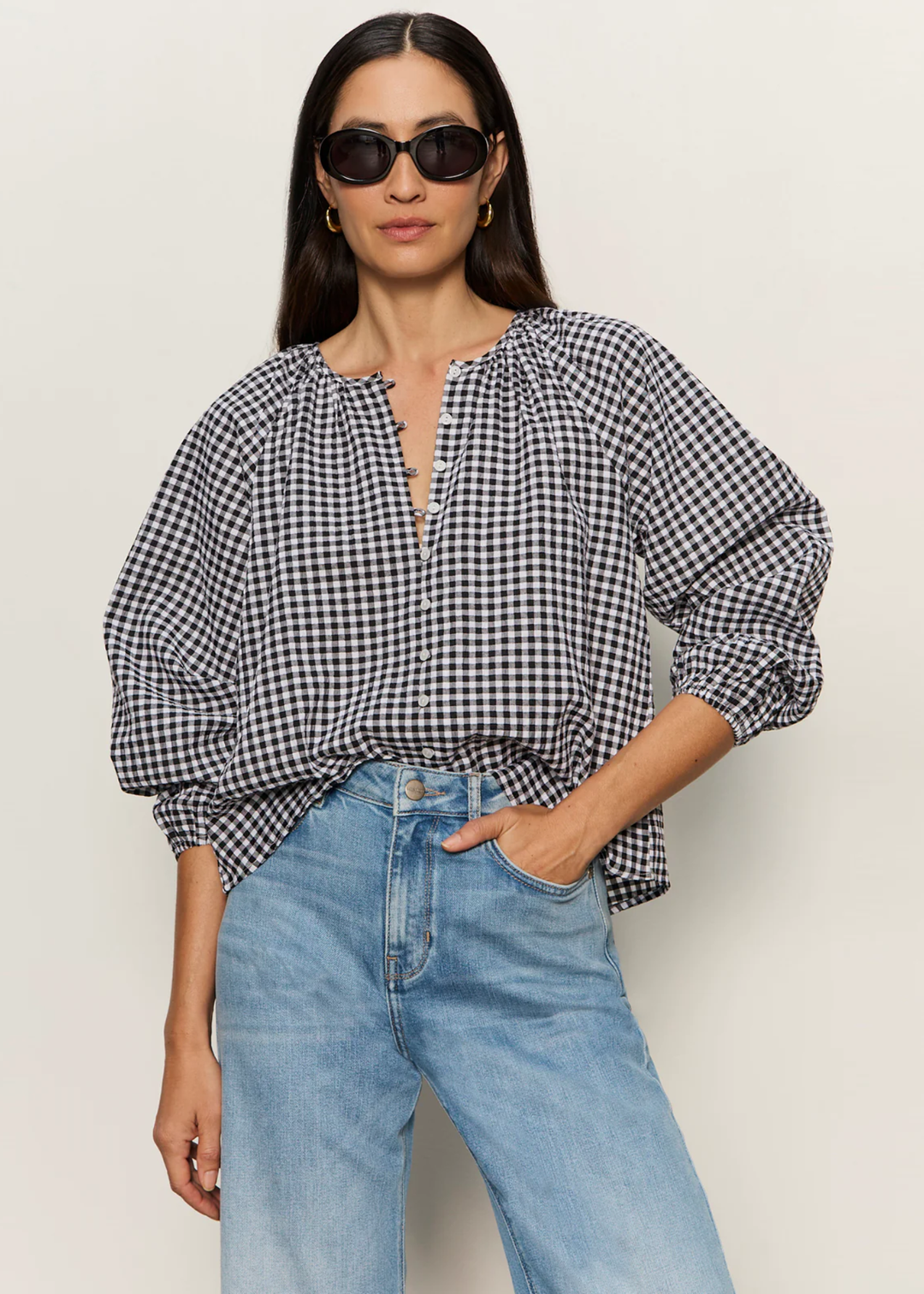 Woman wearing a black and white gingham top with jeans